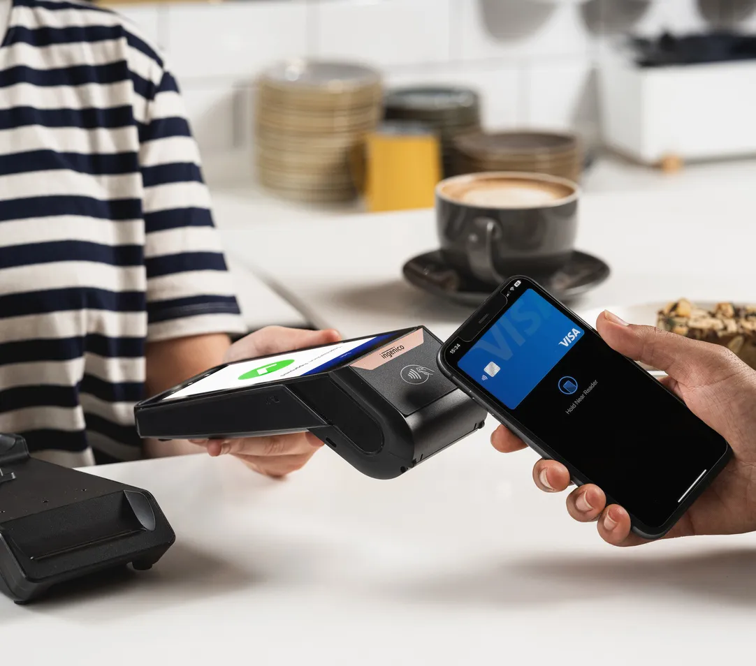 Kontaktlose zahlung mit smartphone und zahlungsterminal im café