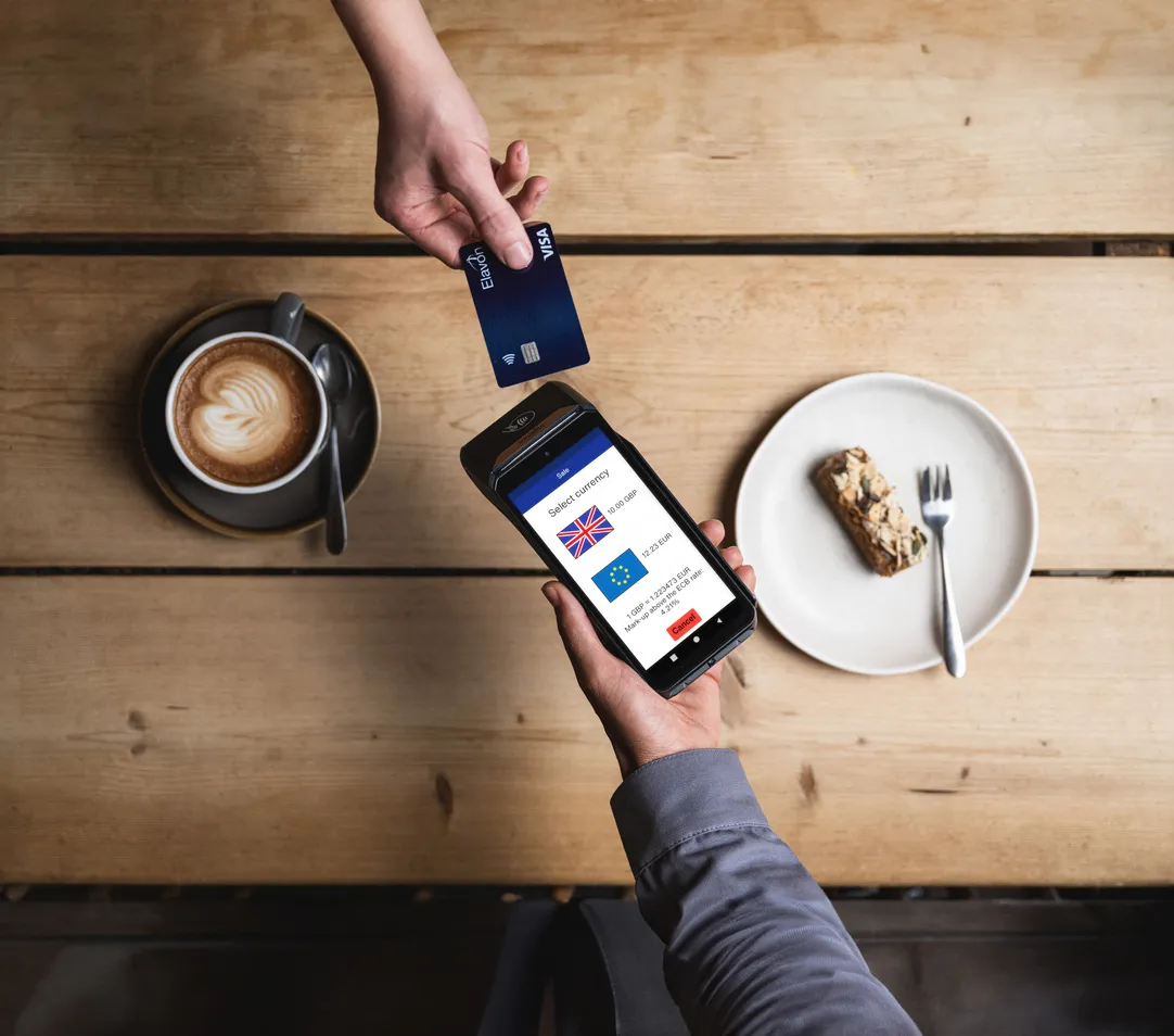 DX8000-Zahlungsterminal im Einsatz mit einer Smartwatch – zeigt die kontaktlose Zahlungstechnologie von Elavon in einem realen Einzelhandelsumfeld